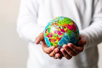 A child's hands holding a miniature globe